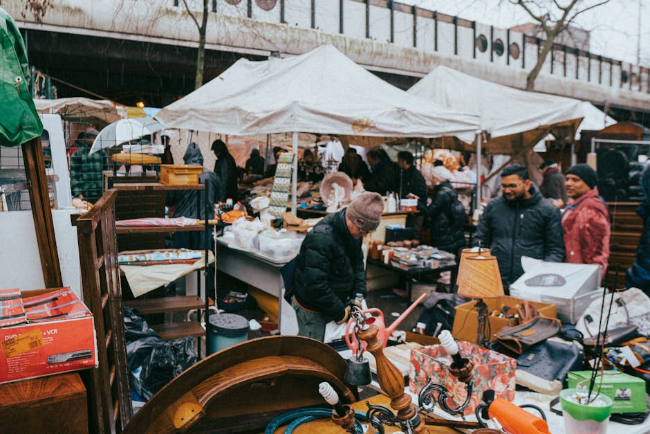A large outdoor area filled with multiple stacks of cardboard fruit and vegetable crates, primarily made of light-colored wood with some black plastic crates visible in the background. The crates feat